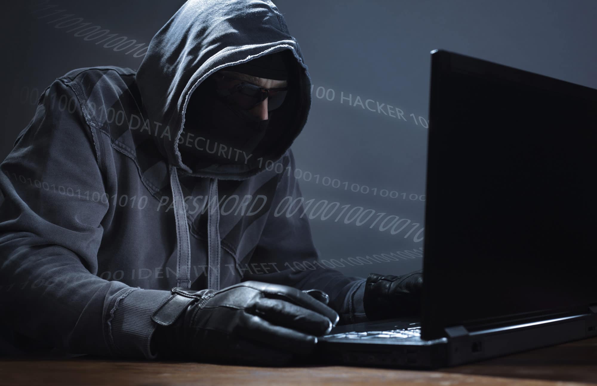 Faceless character with black gloves doing password hacking online within the mainframe